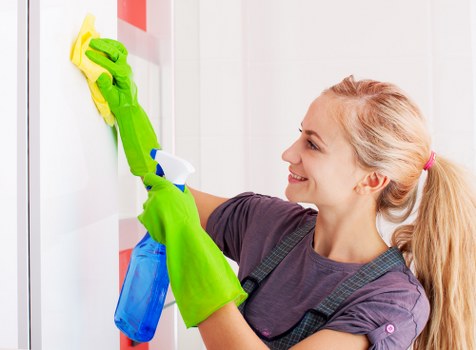Professional cleaner wiping dust from renovated surfaces in SE22